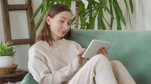 Woman Relaxing at Home with Tablet