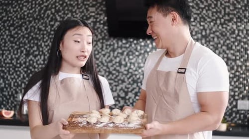Young Couple Cooking Dumplings Together in Kitchen
