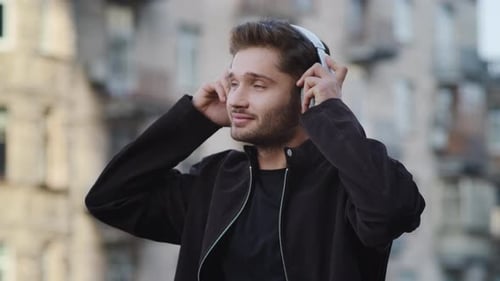 Man Puts On Headphones In City, Listens To Music