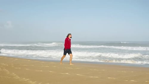 Homem caminha ao longo da costa enquanto observa as pitorescas marés gigantescas
