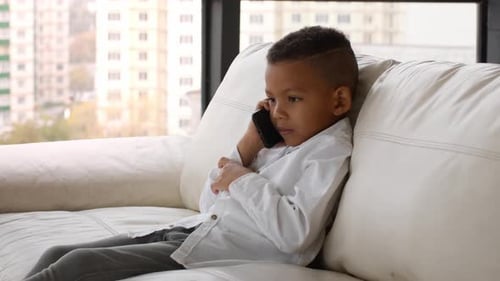 Child Talking on Smartphone on Couch