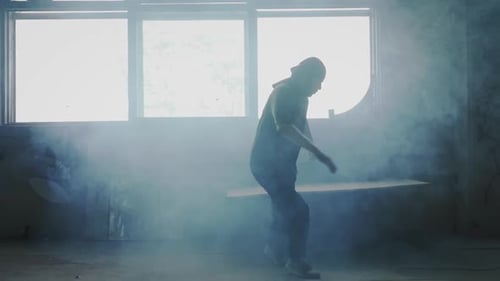 Energetic Dancer Performing in Smoky Urban Room