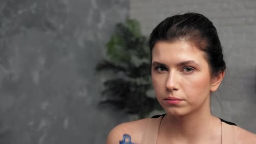 Young Woman Drinks Water After Workout