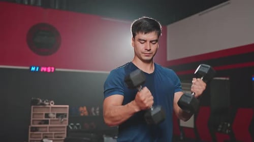 Caucasian attractive young sportsman workout exercising lifting weight dumbbells in gym stadium