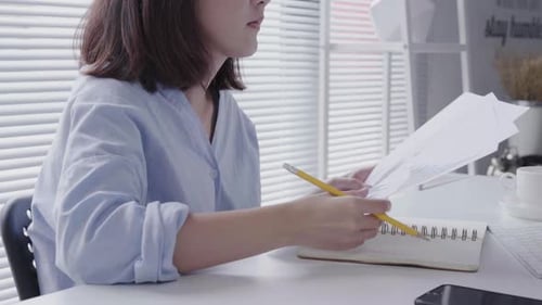 Young Adult Woman Working at Desk with Documents