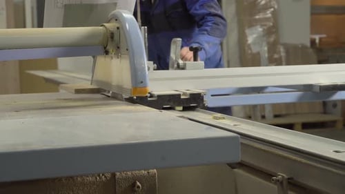 Factory Worker Cuts Wood on a Machine