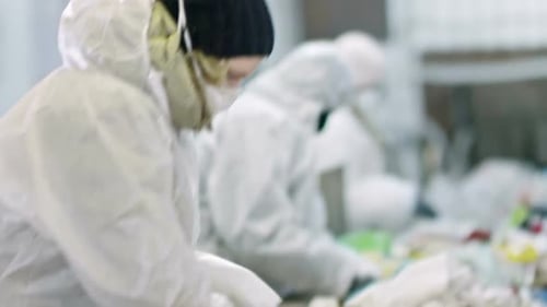 Recycling Workers Sorting Garbage on Conveyor Belt