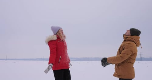 Jeune couple jetant de la neige au Ralenti
