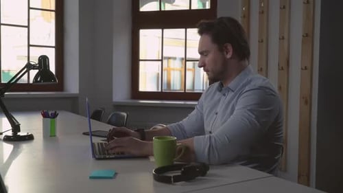 Man Typing on Laptop at Workplace Desk