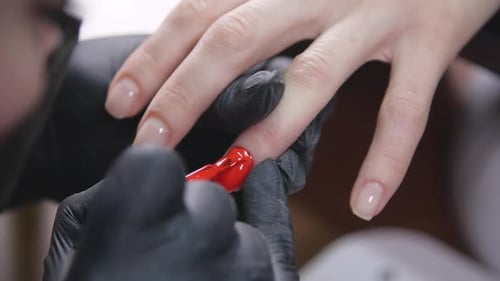 Manicurist Applying Red Nail Polish in Salon