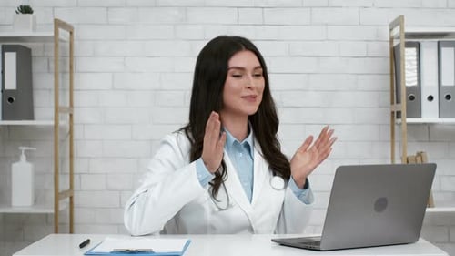 Doctor Lady Talking To Laptop Consulting Patient Online In Office