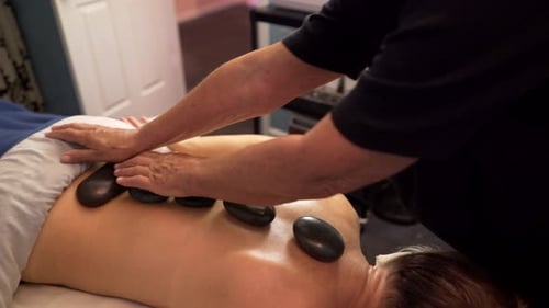 Die
Masseurin oder Massagetherapeutin verwendet erhitzte Steine auf dem Rücken und den Händen einer reifen, schönen Frau. Steadi