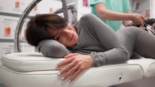 Woman Receives Electronic Massage Treatment in Medical Setting