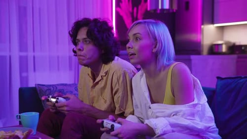 Couple Playing Video Games at Home at Night