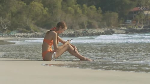 Woman Relaxing with Cellphone on Tropical Beach