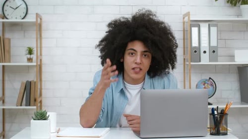 Young Adult Speaking at Desk with Laptop