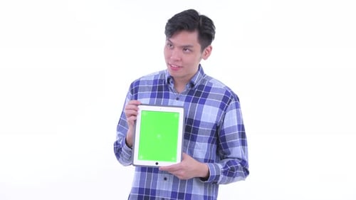 Young Adult Holds Tablet with Green Screen