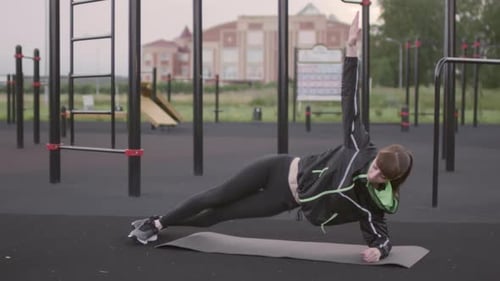 Sporty Woman Doing Side Plank Hip Lifts at Outdoor Workout Place