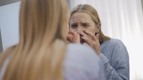 Verärgerter Teenager überprüft den Zustand der Gesichtshaut, dermatologische Probleme, Körperpflege