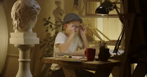 Child Drawing at Desk in Art Studio