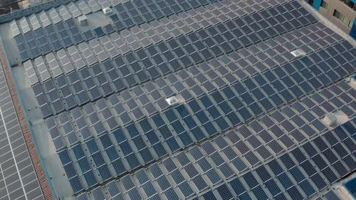 Aerial Drone View Flying Over Warehouse with Solar Panels, Sunny Batteries