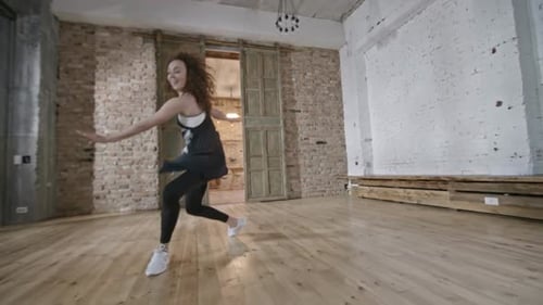 Energetic Woman Dancing in Modern Studio