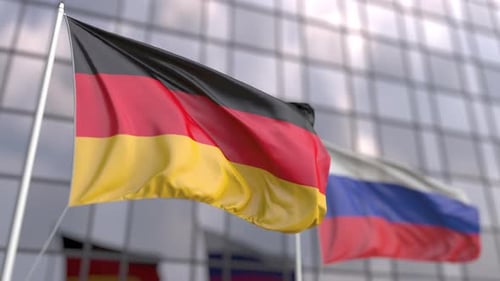 Ondeando banderas de Alemania y Rusia frente a un rascacielos