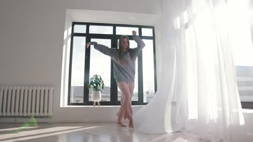 Young Woman Dancing Barefoot in Bright Room