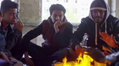 Refugiados sin hogar sentados junto al fuego
