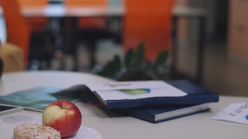 Business Handshake Over Workplace Documents and Healthy Snacks