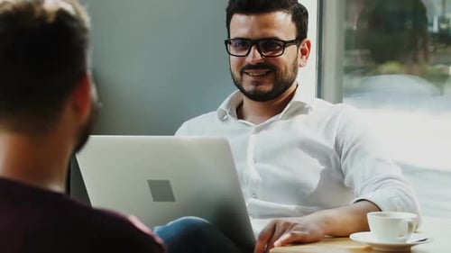 Intelligent Bearded Man in Formal Shirt Discussing Work at Job Unterview with Male Employee