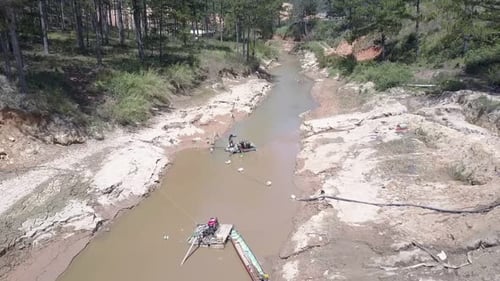 Travaux d'extraction de gravier sur la surface étroite et boueuse d'une rivière