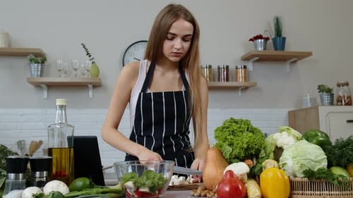 Woman Prepares Healthy Meal at Home with Tablet