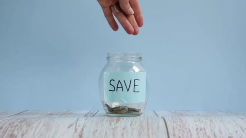 Saving Money with Coins in Glass Jar