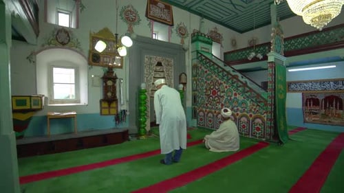Muslimische Männer beten in Robe und Turban an der kleinen historischen Holzmasjid