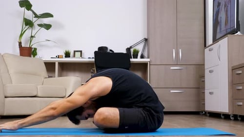 Man Practices Yoga on Mat at Home