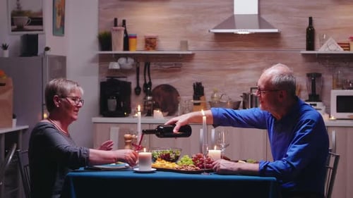 Older Couple Enjoying Romantic Candlelight Dinner At Home