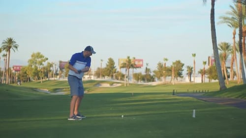Golfer Tees Off on Green Golf Course