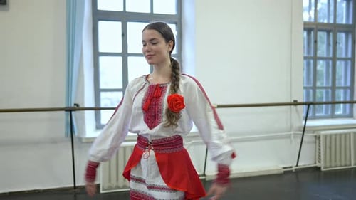 Foto mediana de una joven y encantadora mujer alegre bailando danza folclórica ucraniana en traje nacional