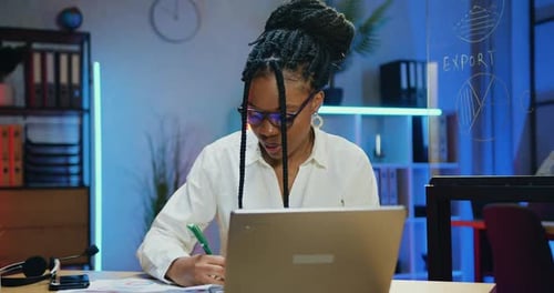 Femme d'affaires en lunettes travaillant avec des papiers et des informations informatiques au bureau du soir