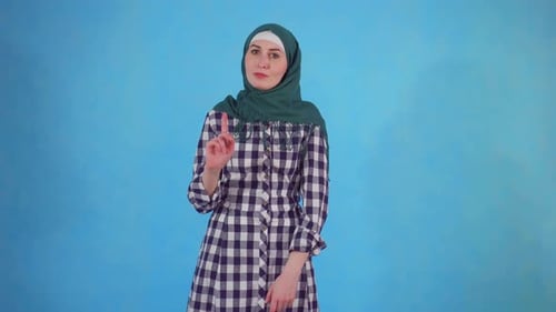 Woman Wearing Headscarf Gesturing Against Blue Background