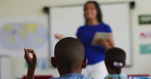 Children in a Classroom Raise Their Hands