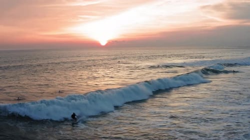 Aerial View of Surfer Riding Sunset Ocean Wave. Drone Shot Surfing Ocean Lifestyle, Extreme Sports.