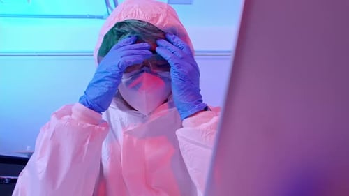 Medical Researcher in Hazmat Suit Working at Computer