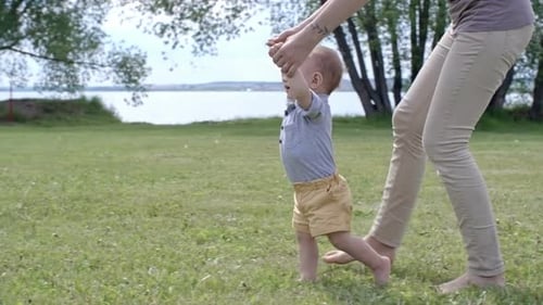 Mother Helping Toddler Taking First Steps