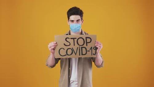 Young Adult Holding Stop Covid-19 Sign