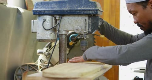 Man Using a Drill Press on Wood