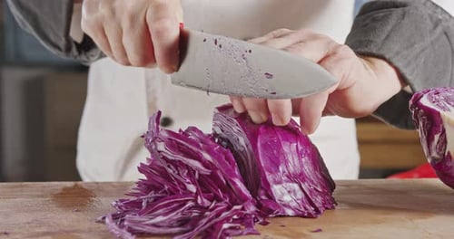 Slow motion close up of a chef knife slicing a Red cabbage