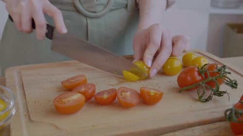 Slicing Cherry Tomatoes on a Wooden Board