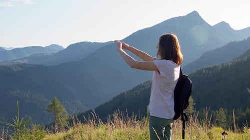 Female Tourist Taking a Photo on Top of a Mountain